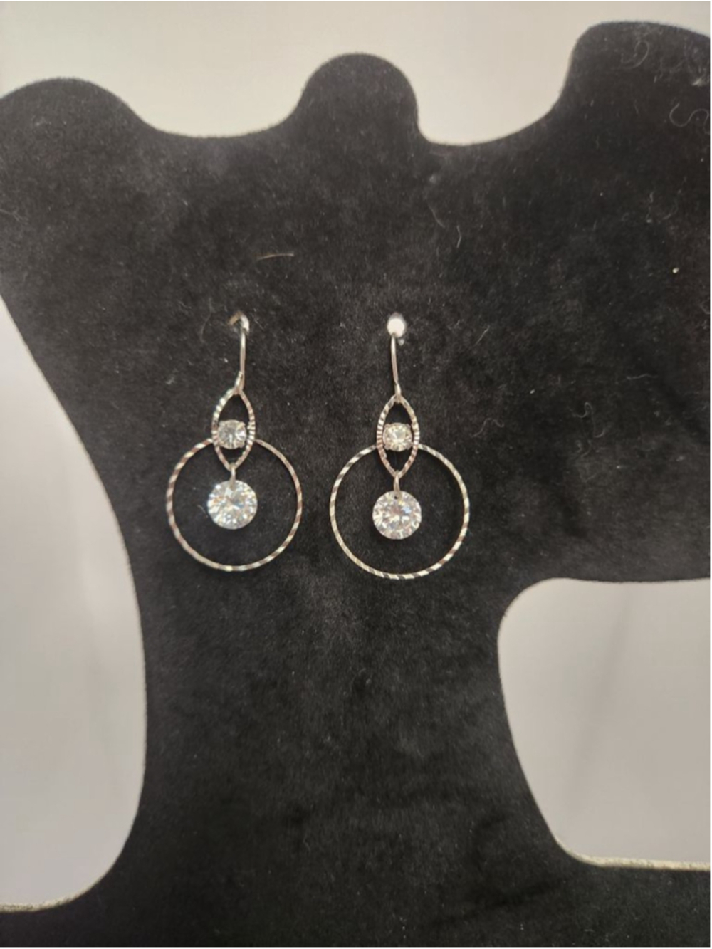 SIilver toned dangle earrings featuring a floating circular design